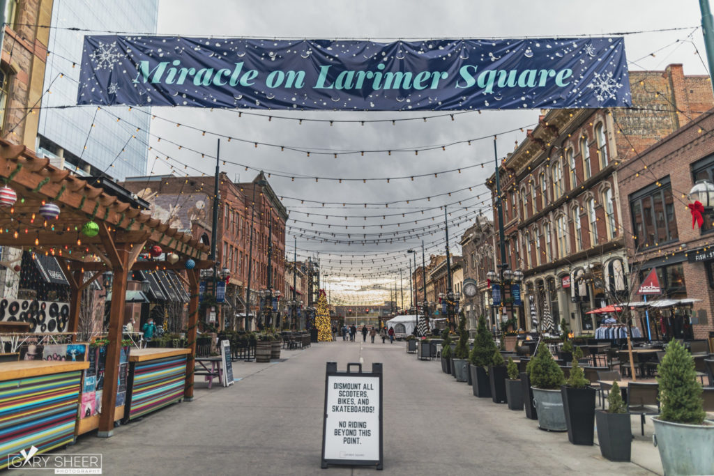 Landscape photo of Larimer Square with sign in the foreground and people walking down the street in the distance © Gary Sheer Photography