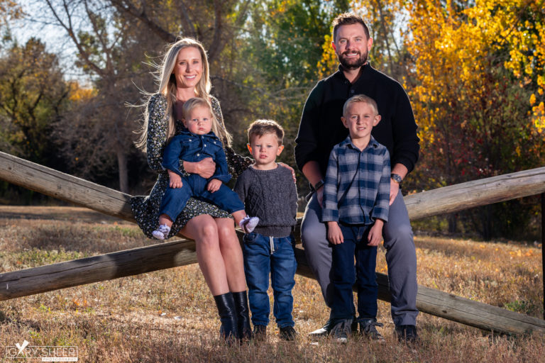 Family sitting on wooden fence for family portrait in Denver Co © Gary Sheer Photography